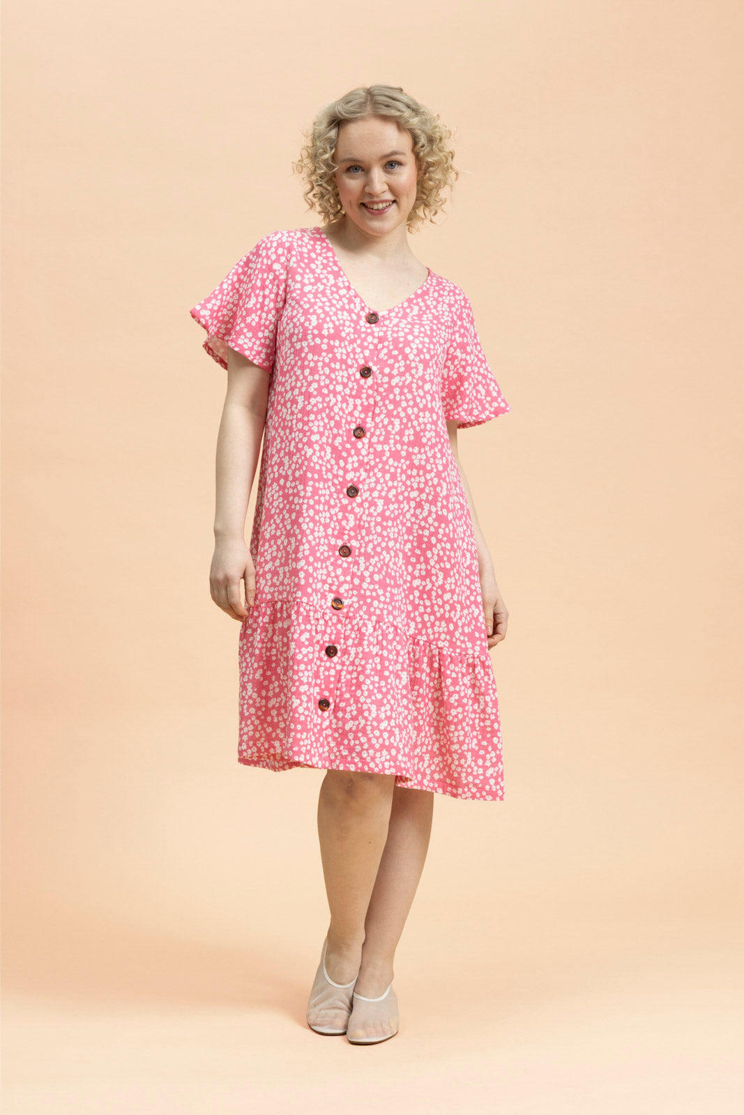 Naisten pinkki musliininen t-paitamekko minimalistisella kukkakuosilla | modelheight:164, size:XS