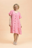 Naisten pinkki musliininen t-paitamekko minimalistisella kukkakuosilla | modelheight:164, size:XS